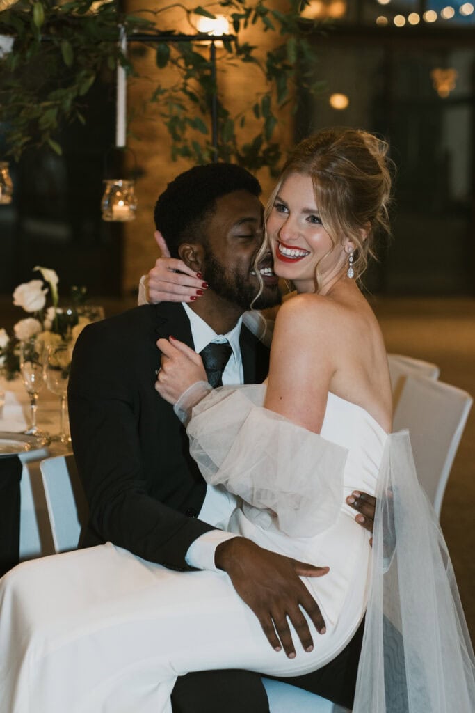 couple laugh embracing each other during small wedding reception