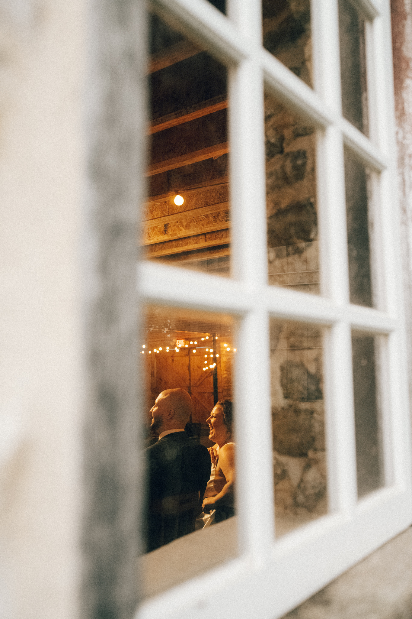 documentary style photo of minnesota bride and groom laughing through winder