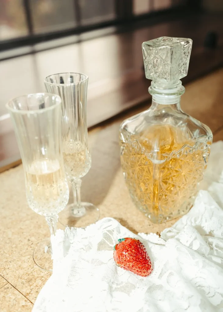 Champagne glasses and vintage decanter with lace and strawberry detail