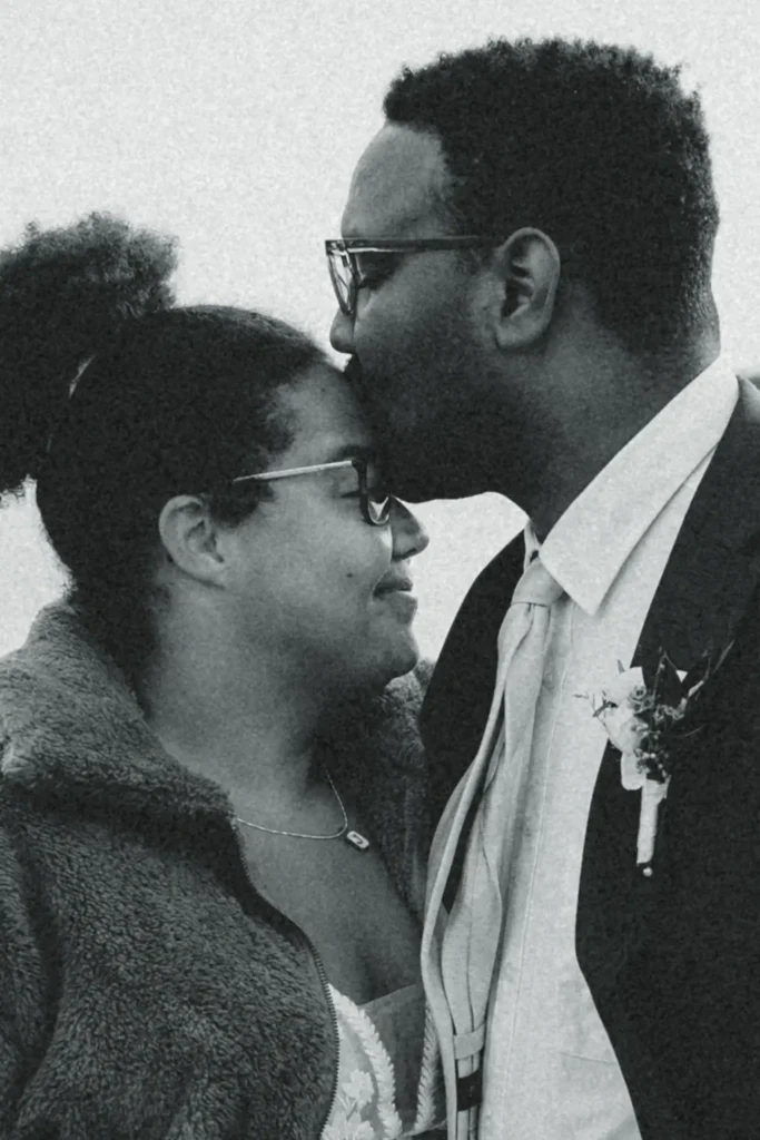 Groom kissing partner’s forehead