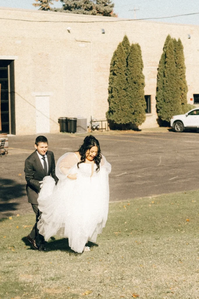 Bride and groom walking uphill with dress in motion
