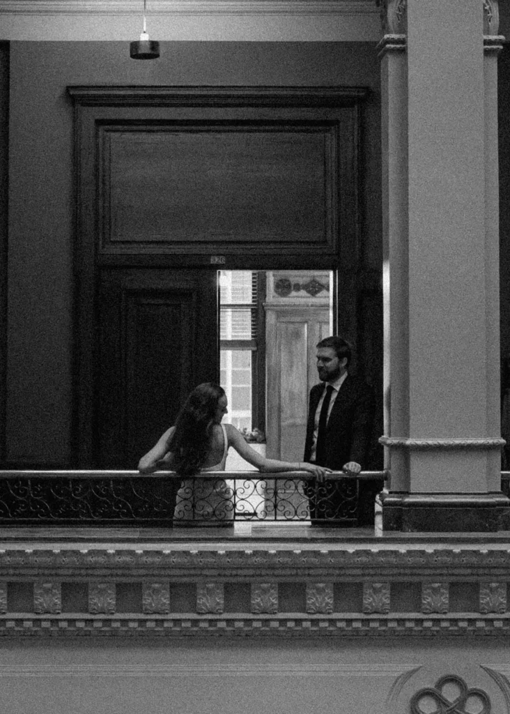 Couple standing on a historic balcony during engagement session