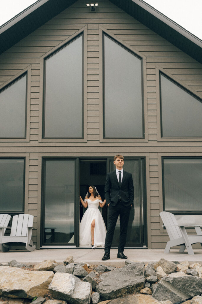bride and groom prepare for first look outside a-frame cabin