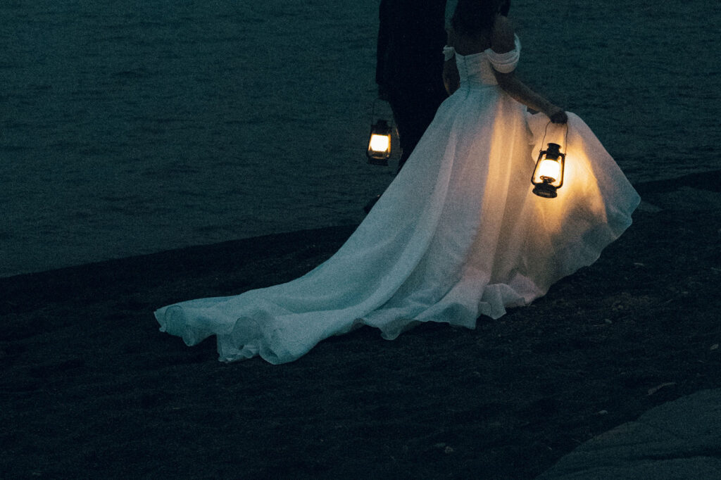 bride and groom walk along the shores of lake superior